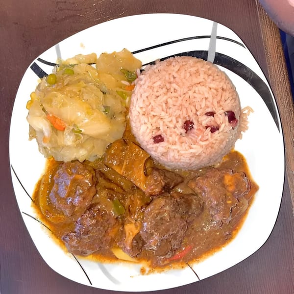A plate of Jamaican oxtail stew, rice and peas, and steamed cabbage from Island Grill AZ.