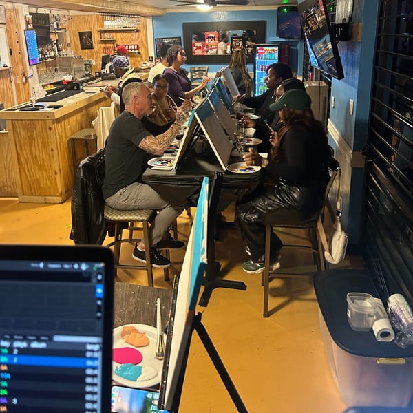 Customers at Island Grill AZ enjoying a paint and sip event with easels and drinks.