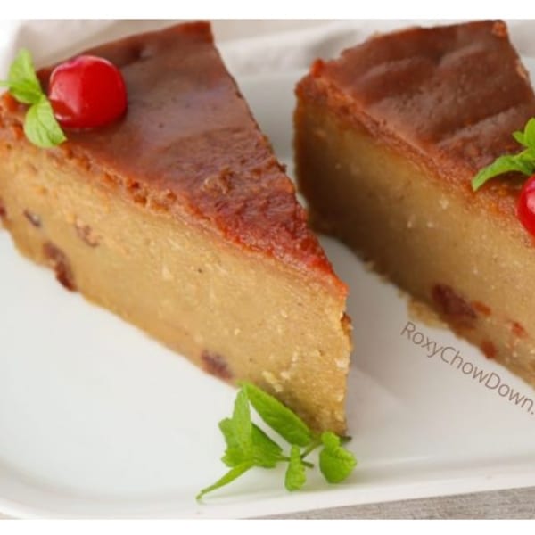 Two slices of Jamaican sweet potato pudding, garnished with a cherry and mint leaves.
